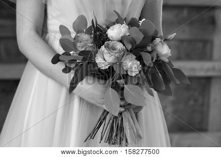 The bride holds a wedding bouquet. The bride's bouquet. Black and white. Close-up.