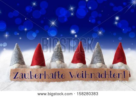 Label With German Text Zauberhafte Weihnachten Means Magic Christmas. Christmas Greeting Card With Gnomes. Sparkling Bokeh And Blue Background With Snow And Stars.
