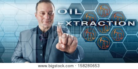 Smiling businessman is activating the phrase OIL EXTRACTION on an interactive control screen. Technology concept and business metaphor for the petroleum industry and onshore crude oil production.