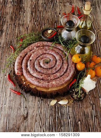 raw beef sausages with rosemary and spices on a wooden table, South African boerewors