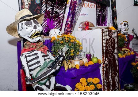 OAXACA, OAXACA, MEXICO - NOVEMBER 1, 2016: Part of a day of the dead offering altar with big skulls made of paper, flowers and cut paper in Oaxaca, Oaxaca, Mexico