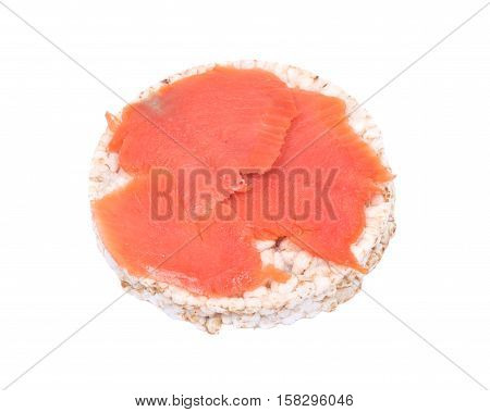 Smoked wild pacific sockeye salmon on organic brown rice cake isolated on white background