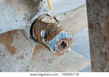 Selective focus of detail old rusty ship propeller waiting for cleanup and repair of old yacht boat at shipyard