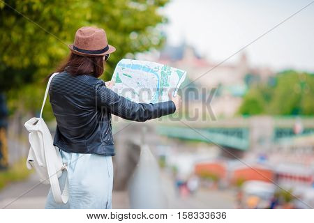 Young beautiful girl with city map in Europe