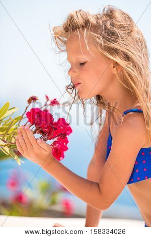 Adorable little girl enjoying smell in a flowering spring garden