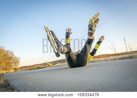 Inline skating accident - male skater falling on concrete bike trail,l ate fall scenery in Colorado