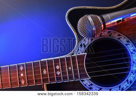 Acoustic Guitar And Microphone Isolated With Red And Blue Lights