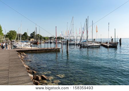 BARDOLINO, ITALY - MAY 4, 2016: Sailboats and fishing boats at Porto di Bardolino harbor on The Garda Lake . Italy