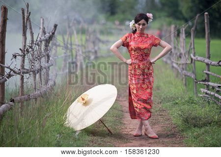 Portrait beautiful Chinese girl with dress traditional Cheongsam concept in Garden