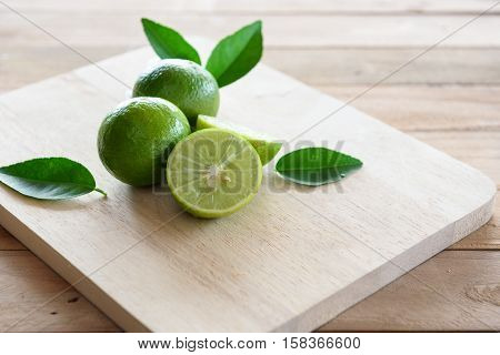 Lemons with green leaf on wooden background
