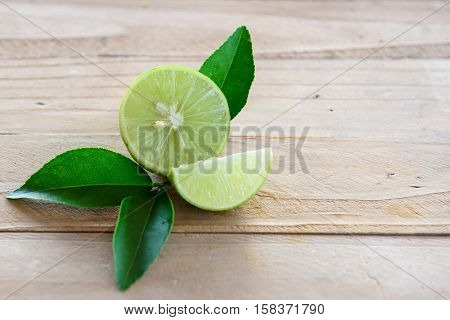 Lemons with green leaf on wooden background