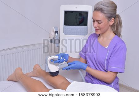 Young beautiful woman gets professional body shape treatment in a beauty clinic