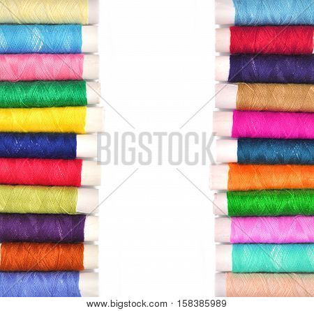 Pile of coloured bobbins of lurex thread isolated on white