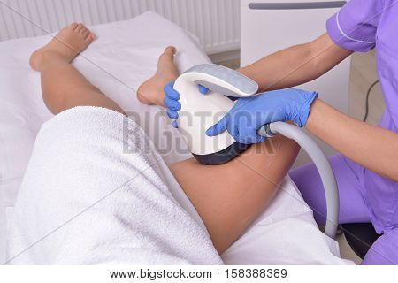 Young beautiful woman gets professional body shape treatment in a beauty clinic