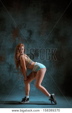 Attractive girl dancing twerk iat the blue studio background