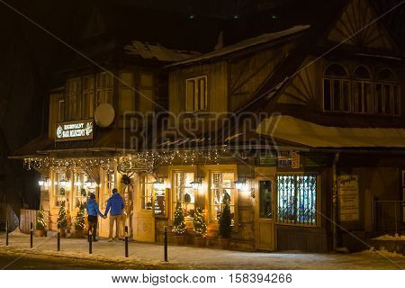 POLAND ZAKOPANE - JANUARY 03 2015: Traditional wooden restaurant on the street in Zakopane in the Christmas decoration. Town known as the winter capital of Poland. It is a popular destination for tourism.