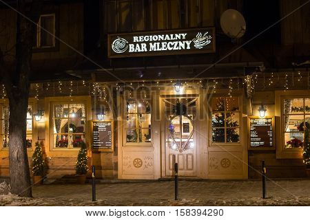 POLAND ZAKOPANE - JANUARY 03 2015: Traditional wooden restaurant on the street in Zakopane in the Christmas decoration. Town known as the winter capital of Poland. It is a popular destination for tourism.