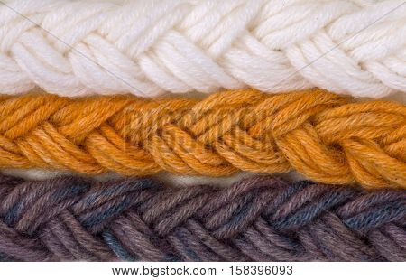 Braided wool yarn swatches colored by henna and indigo and control white sample
