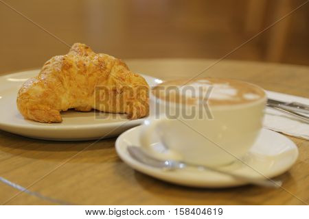 Breakfast with coffee latte art and croissant. Coffee break business