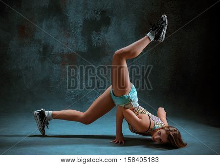 Attractive girl dancing twerk iat the blue studio background