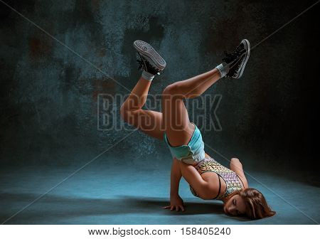 Attractive girl dancing twerk iat the blue studio background