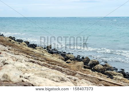 blue ocean with big rocks at shore