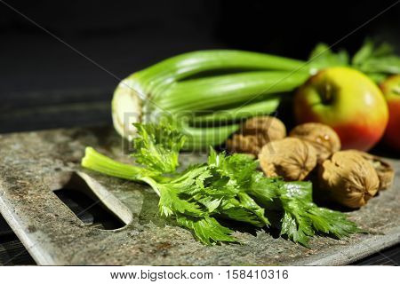 Ingredients for Waldorf salad - celery apples walnuts - fresh and healthy vegetables on granite board.