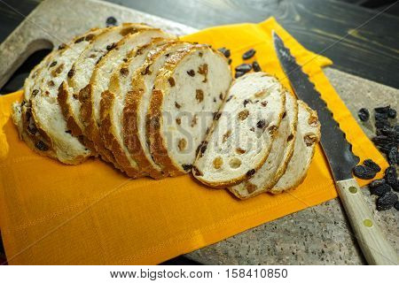Fresh baked raisins bread sliced on granite board