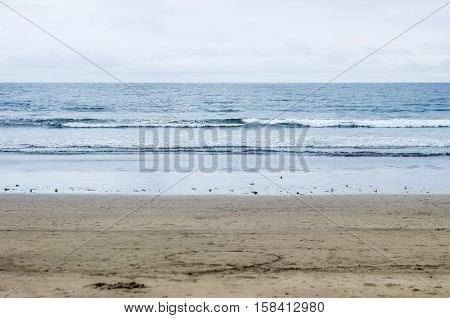 sandy beach and blue ocean with cloudy sky