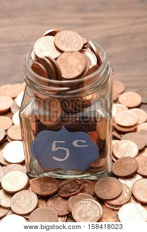 A bottle filled with five cents South African coins