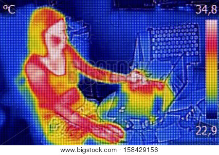 Infrared thermography image showing the heat emission when woman used notebook
