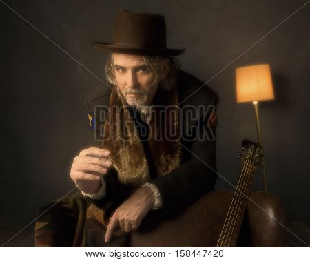 Vintage 1970S Guitarist Leaning On Back Of Chair And Smoking Cigarette.