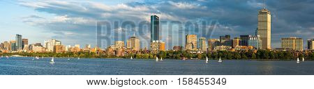Boston Massachusettes Back Bay Distric with dark clouds behind and sailboats on the Charles River
