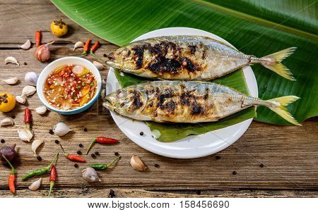 grilled fish with spicy sauce on wooden background