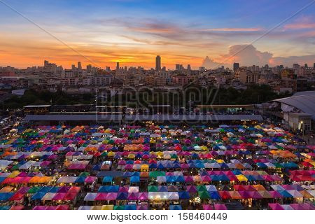 Dramatic after sunset sky over city downtown colourful night market aerial view