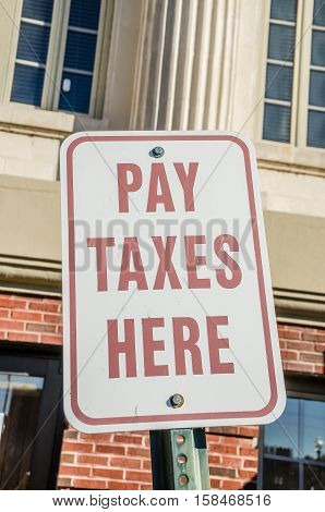 Easy to see sign in front of the building where you go to pay your taxes. No excuses with a sign like this!