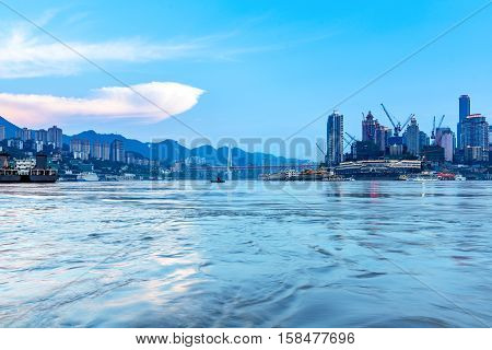 cityscape and skyline of downtown near water of chongqing at night