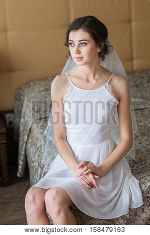 beautiful and gentle bride holds her wedding dress. morning bride concept.