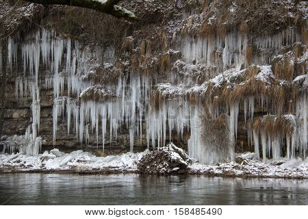 Jagst in the winter / Icicles hang from the bluff to the river.