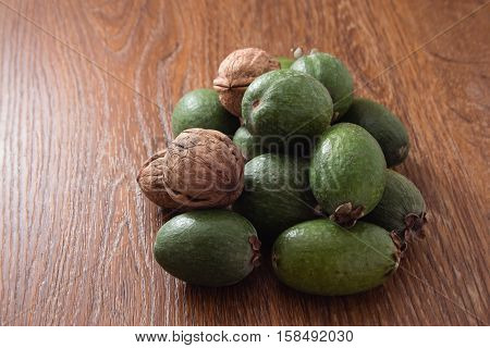 Feijoa Fruit And Walnuts On Wooden Background