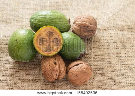 Feijoa fruit and walnuts on linen background