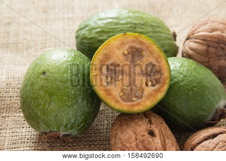 Feijoa fruit and walnuts on linen background