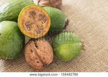 Feijoa fruit and walnuts on linen background