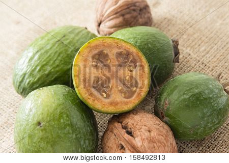 Feijoa fruit and walnuts on linen background