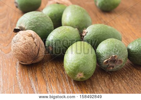 Feijoa fruit and walnuts on linen background