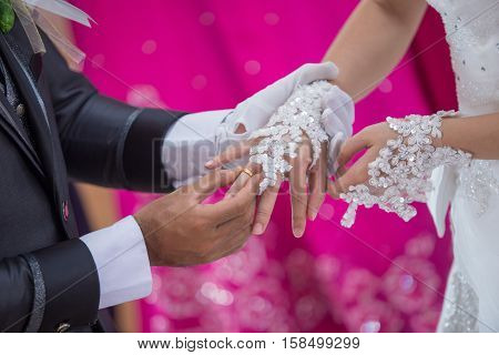 a man putting the wedding ring on his brides finger in holy matrimony