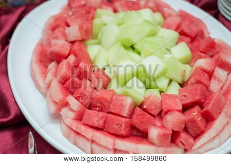 Melon and watermelon small slices in white dish