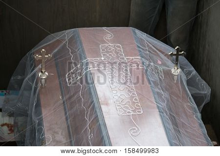 Dark wooden coffin with Jesus crucifix fabric