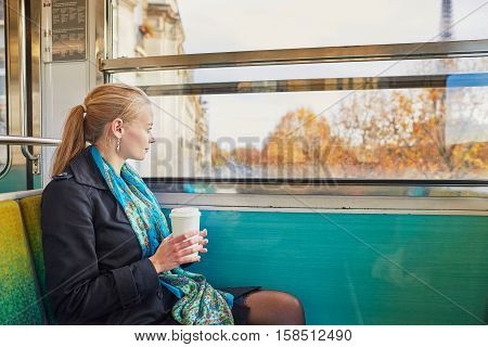 Beautiful Young Woman Travelling In A Train Of Parisian Underground And Drinking Coffee