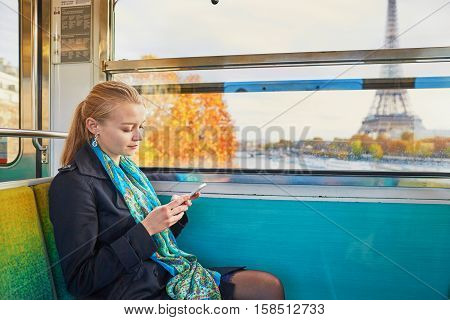 Beautiful Young Woman Travelling In A Train Of Parisian Underground And Using Her Mobile Phone